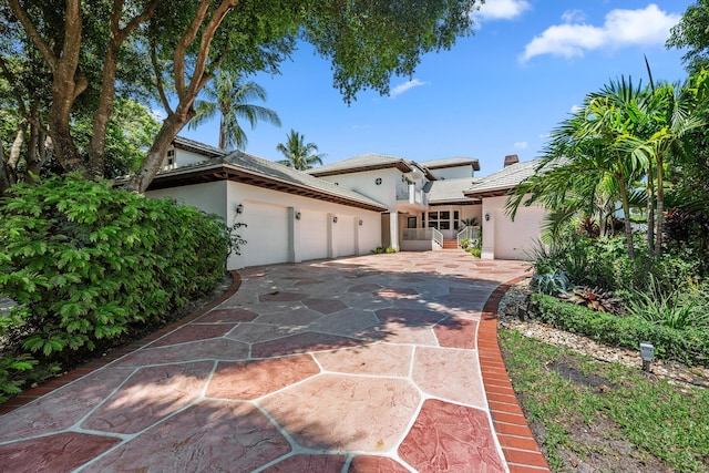 2 Firestone Cir, West Palm Beach, FL 33401 - view of front of home featuring stucco siding, an attached garage, and driveway