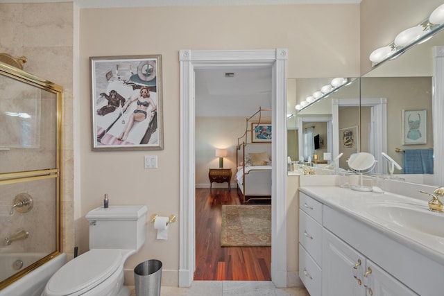 2 Firestone Cir, West Palm Beach, FL 33401 - ensuite bathroom with vanity, wood finished floors, bath / shower combo with glass door, and toilet