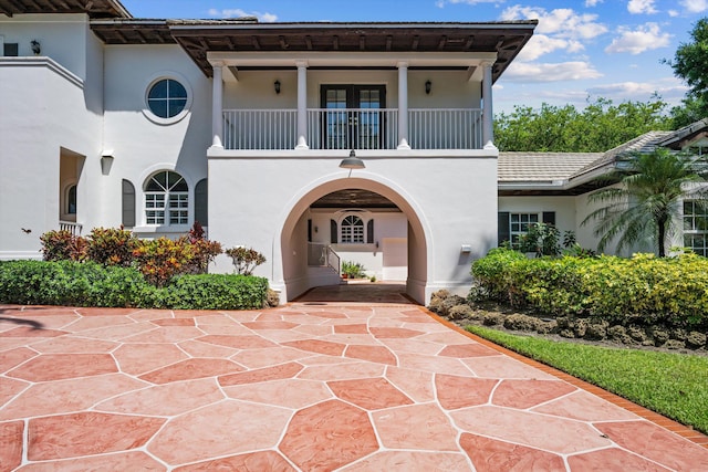 2 Firestone Cir, West Palm Beach, FL 33401 - view of front of house with a balcony, stucco siding, and french doors