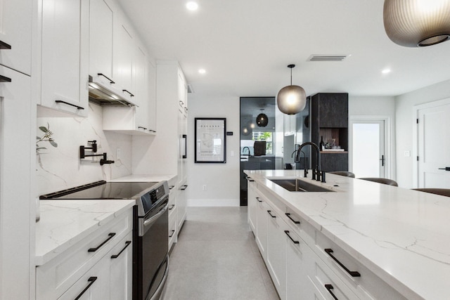 3401 S Ocean Blvd Unit 6, Highland Beach, FL 33487 - kitchen featuring stainless steel range with electric stovetop, a sink, under cabinet range hood, recessed lighting, and white cabinets