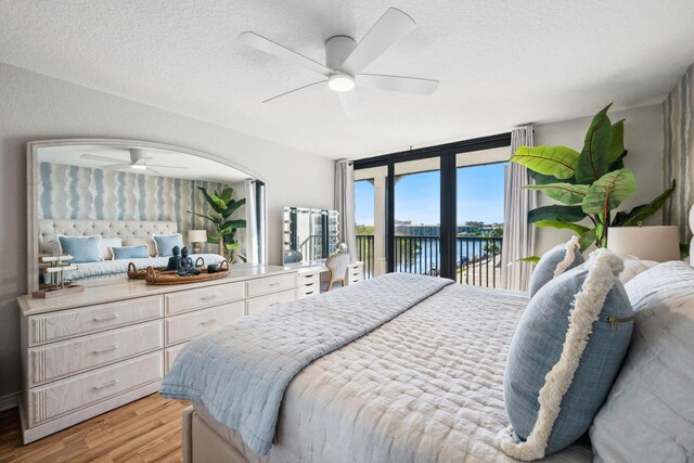 1627 Riverview Rd Unit 409, Deerfield Beach, FL 33441 - bedroom with access to exterior, a water view, light wood-style flooring, a ceiling fan, and a textured ceiling