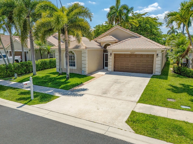 1833 Barnstable Rd, Wellington, FL 33414 - mediterranean / spanish home with a tile roof, stucco siding, a garage, a front lawn, and concrete driveway