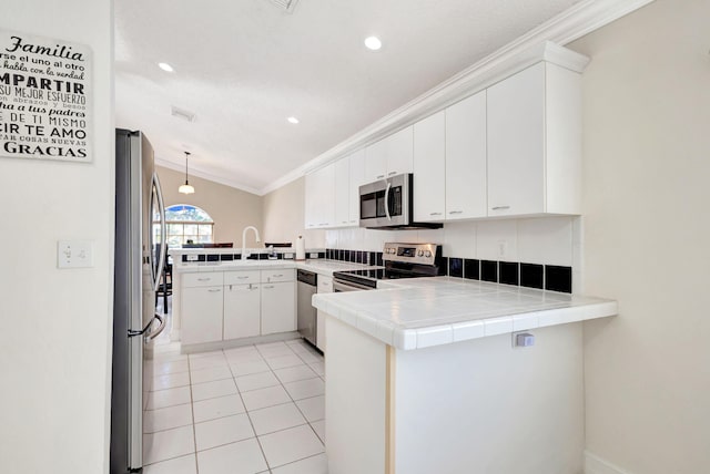 1833 Barnstable Rd, Wellington, FL 33414 - kitchen featuring appliances with stainless steel finishes, a peninsula, crown molding, a sink, and white cabinets