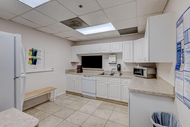 1833 Barnstable Rd, Wellington, FL 33414 - kitchen featuring white appliances, a sink, a drop ceiling, light countertops, and white cabinets