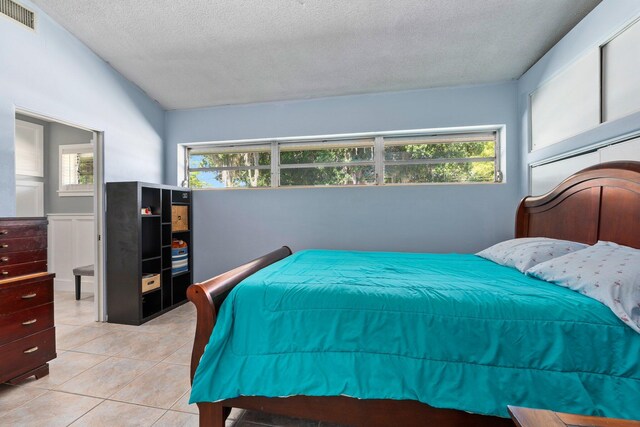 2560 50th Ave, Vero Beach, FL 32966 - bedroom with a textured ceiling and light tile patterned floors