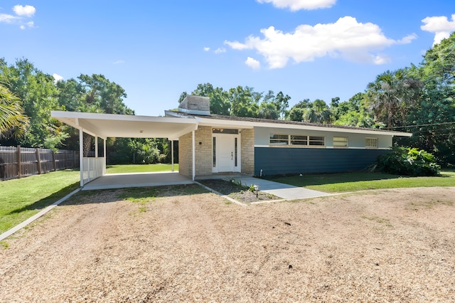 2560 50th Ave, Vero Beach, FL 32966 - view of front facade featuring dirt driveway, an attached carport, and stone siding