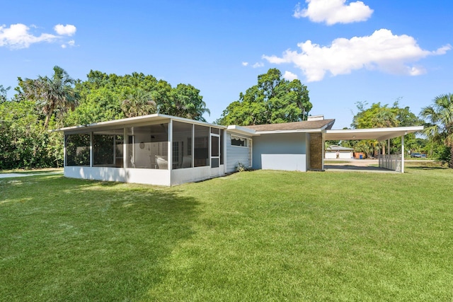 2560 50th Ave, Vero Beach, FL 32966 - back of property featuring a sunroom, a yard, and a carport