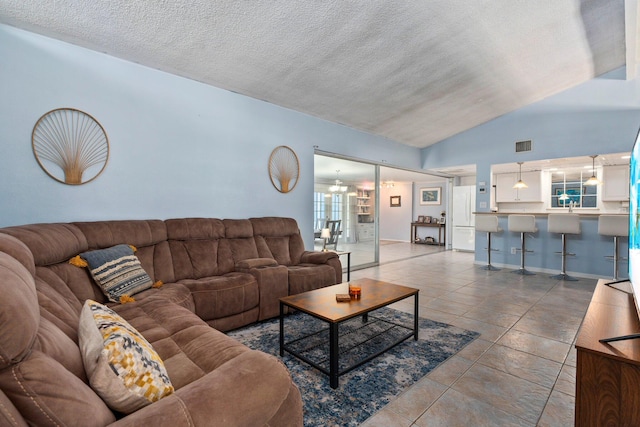 2560 50th Ave, Vero Beach, FL 32966 - living area with lofted ceiling, a textured ceiling, and tile patterned flooring