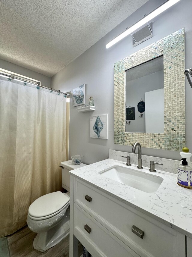 1560 NE 12th Ter Unit D9, Jensen Beach, FL 34957 - full bath featuring a textured ceiling, wood finished floors, toilet, and vanity
