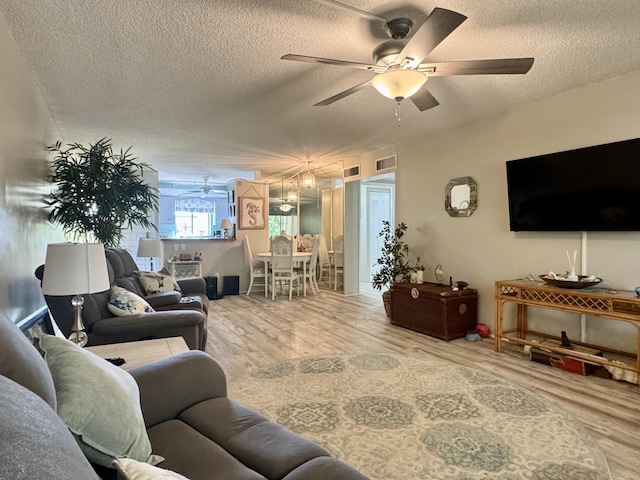1560 NE 12th Ter Unit D9, Jensen Beach, FL 34957 - living area with a ceiling fan, a textured ceiling, and wood finished floors
