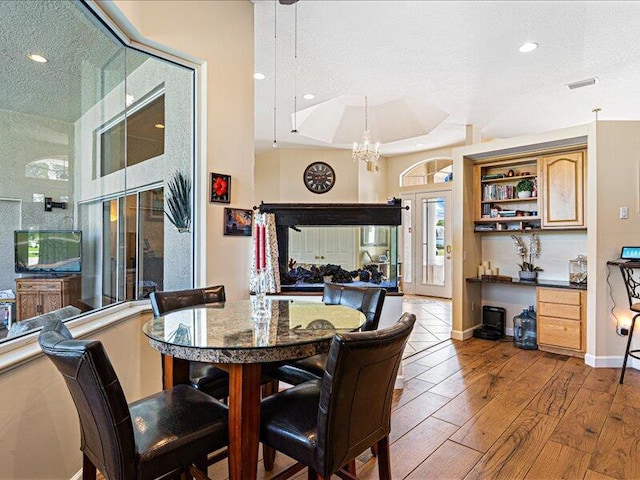 6575 NW Pomona Ct, Port Saint Lucie, FL 34983 - dining room featuring a chandelier, recessed lighting, wood finished floors, and a raised ceiling