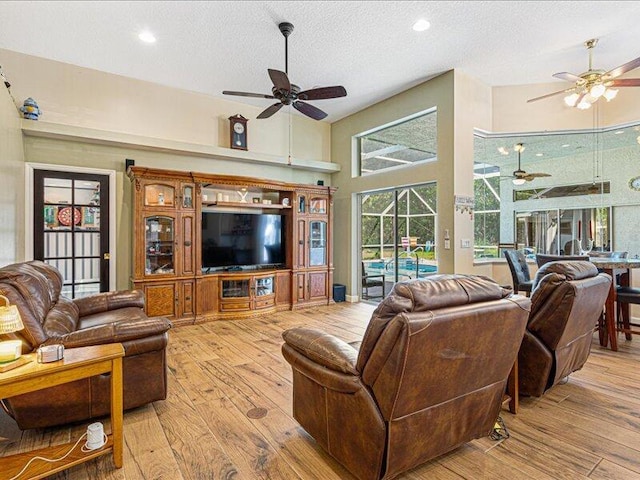 6575 NW Pomona Ct, Port Saint Lucie, FL 34983 - living area with ceiling fan, hardwood / wood-style flooring, a textured ceiling, a high ceiling, and recessed lighting