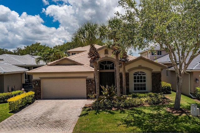 11218 Osprey Lake Ln, Palm Beach Gardens, FL 33412 - mediterranean / spanish-style house with an attached garage, stone siding, stucco siding, and decorative driveway