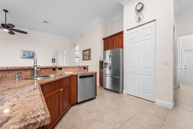 11218 Osprey Lake Ln, Palm Beach Gardens, FL 33412 - kitchen with appliances with stainless steel finishes, a ceiling fan, light tile patterned floors, ornamental molding, and brown cabinetry