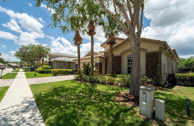 11218 Osprey Lake Ln, Palm Beach Gardens, FL 33412 - view of front of home featuring stone siding, a front yard, and driveway
