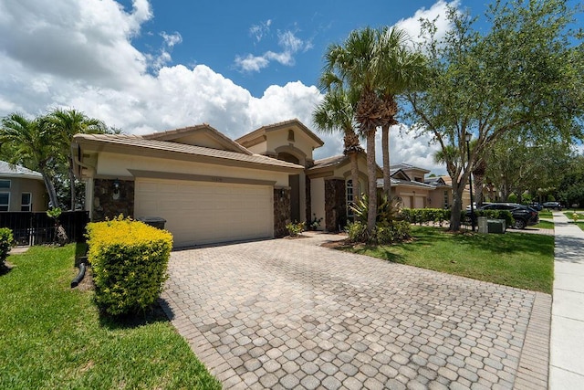 11218 Osprey Lake Ln, Palm Beach Gardens, FL 33412 - mediterranean / spanish-style home with stone siding, decorative driveway, a garage, and a front yard