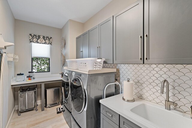 122 Cerulean Key Way, Jupiter, FL 33478 - washroom featuring independent washer and dryer, cabinet space, and light wood-style flooring