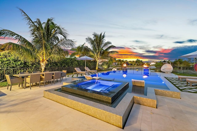 122 Cerulean Key Way, Jupiter, FL 33478 - pool at dusk with an in-ground hot tub, a patio, and outdoor dining space