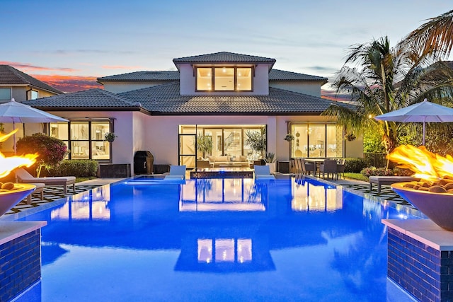 122 Cerulean Key Way, Jupiter, FL 33478 - back of property featuring a hot tub, a tiled roof, an infinity pool, and stucco siding