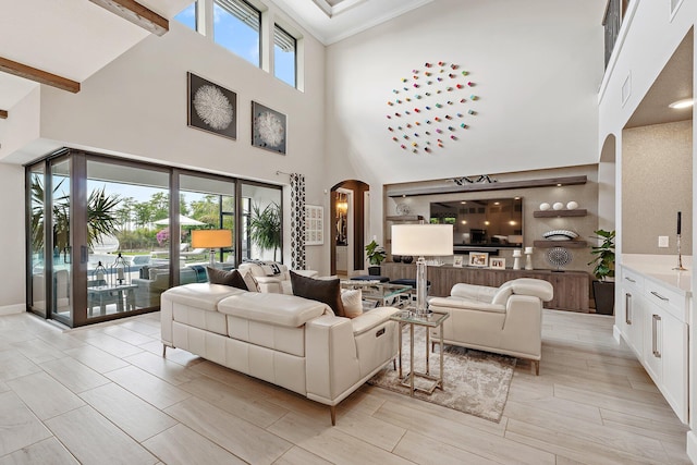 122 Cerulean Key Way, Jupiter, FL 33478 - living room featuring arched walkways, a high ceiling, ornamental molding, and beam ceiling