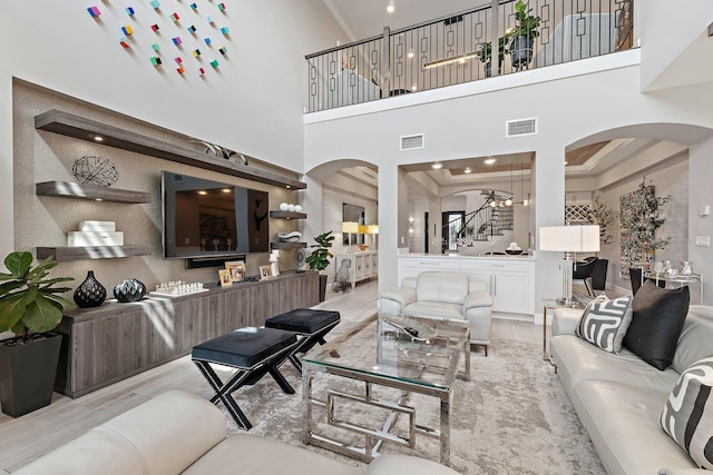 122 Cerulean Key Way, Jupiter, FL 33478 - living room with arched walkways, stairway, ornamental molding, a high ceiling, and wood finished floors