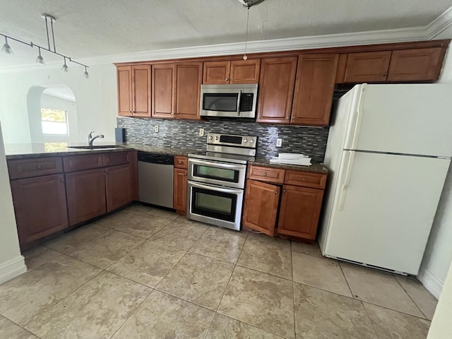 711 Fernwood Dr, West Palm Beach, FL 33405 - kitchen with stainless steel appliances, decorative backsplash, a sink, track lighting, and a textured ceiling