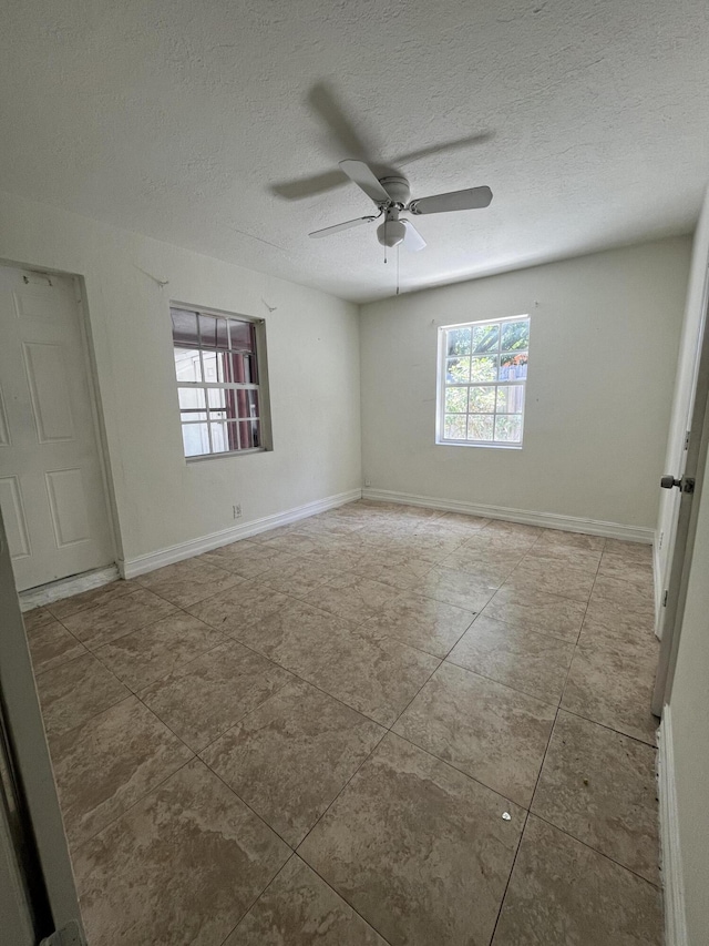 711 Fernwood Dr, West Palm Beach, FL 33405 - empty room featuring ceiling fan, a textured ceiling, tile patterned floors, and baseboards