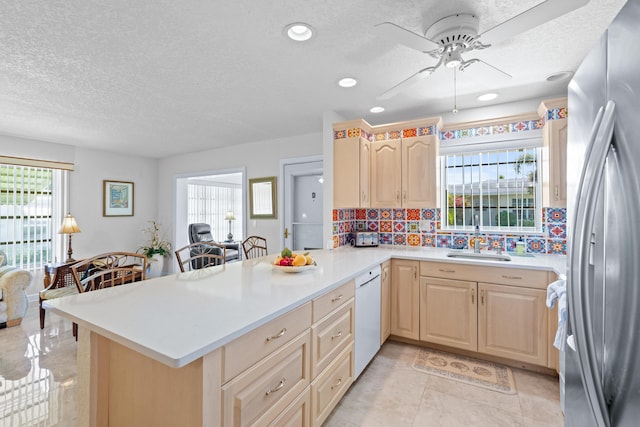 201 Bayview Ave Unit D, Boynton Beach, FL 33435 - kitchen with freestanding refrigerator, dishwasher, light brown cabinetry, a peninsula, and a textured ceiling