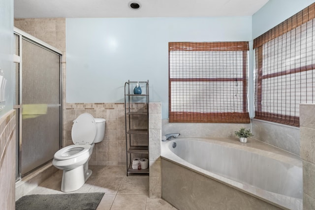 full bathroom featuring toilet, tile walls, a stall shower, tile patterned floors, and a bath