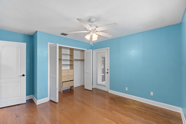 unfurnished bedroom featuring baseboards, a closet, wood finished floors, and a ceiling fan
