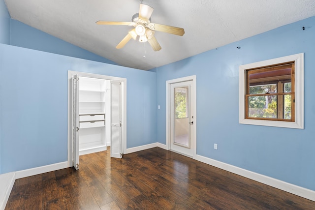 unfurnished bedroom featuring multiple windows, hardwood / wood-style flooring, baseboards, and lofted ceiling