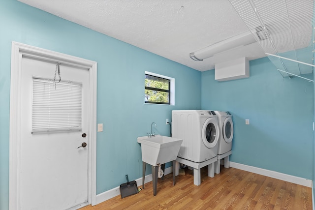 laundry area featuring washing machine and dryer, wood finished floors, and baseboards