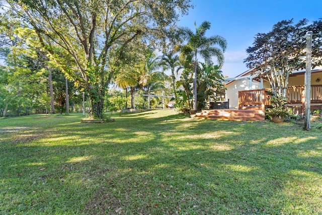 view of grassy yard featuring a wooden deck