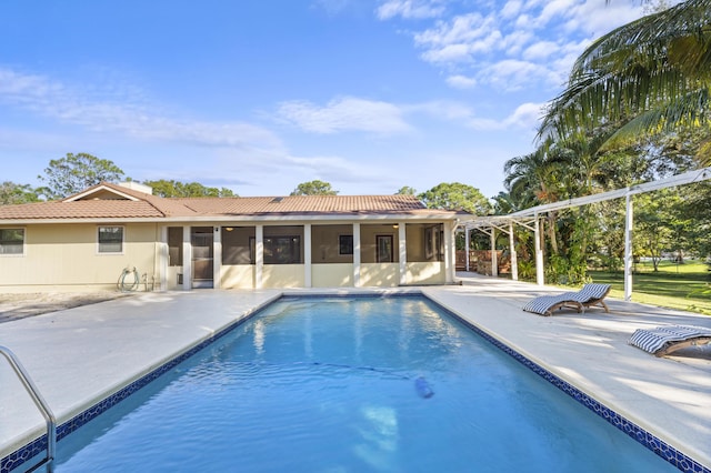 outdoor pool with a patio and a sunroom