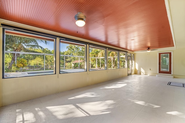 unfurnished sunroom with ceiling fan