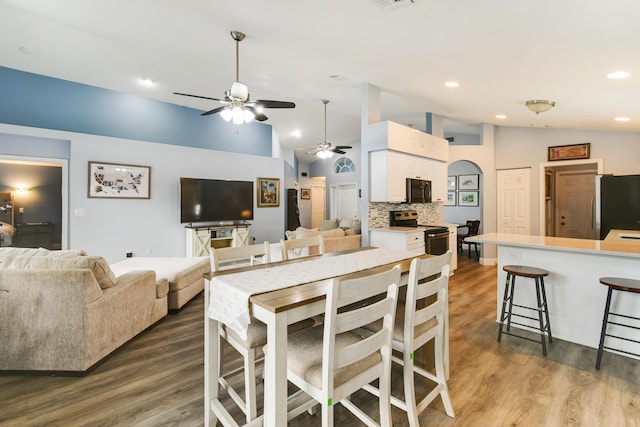1644 Oak Berry Cir, Wellington, FL 33414 - dining area with vaulted ceiling, ceiling fan, dark wood-type flooring, arched walkways, and recessed lighting