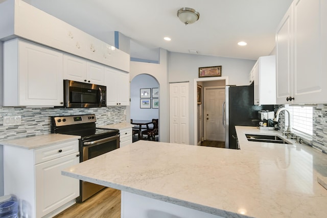1644 Oak Berry Cir, Wellington, FL 33414 - kitchen with stainless steel range with electric stovetop, a sink, tasteful backsplash, white cabinetry, and lofted ceiling
