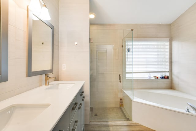 1644 Oak Berry Cir, Wellington, FL 33414 - full bath featuring a garden tub, double vanity, a stall shower, and tile walls