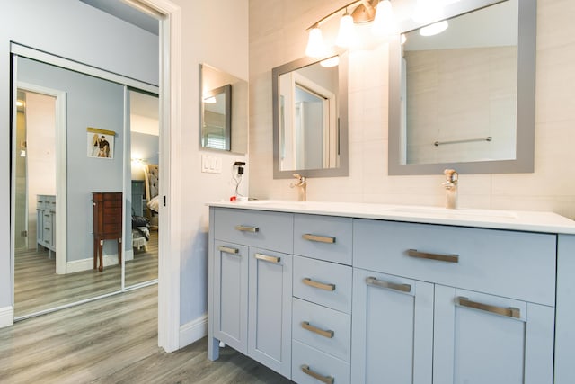 1644 Oak Berry Cir, Wellington, FL 33414 - bathroom featuring double vanity, baseboards, and wood finished floors