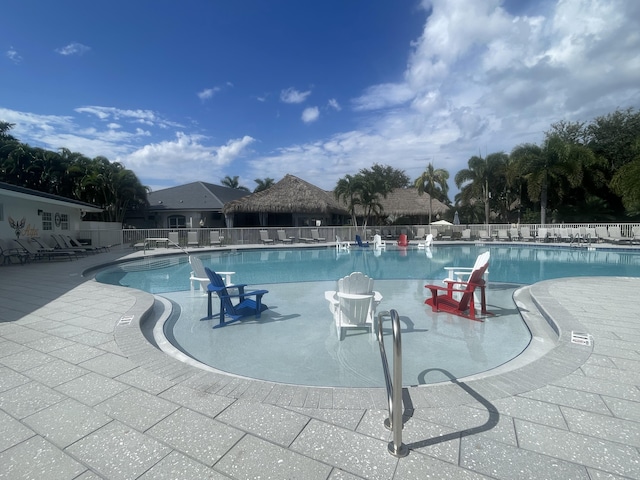community pool featuring fence and a patio area