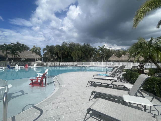 community pool with fence and a patio