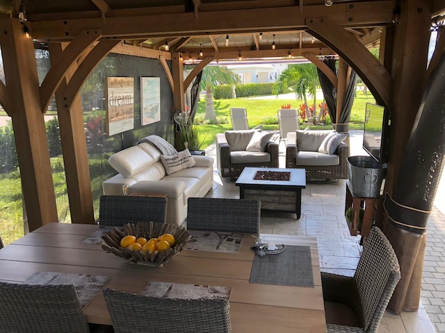view of patio with an outdoor living space with a fire pit and a gazebo