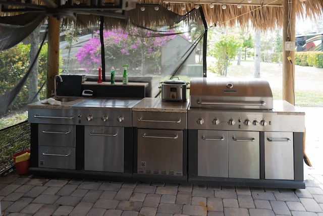 view of patio with an outdoor kitchen and a sink