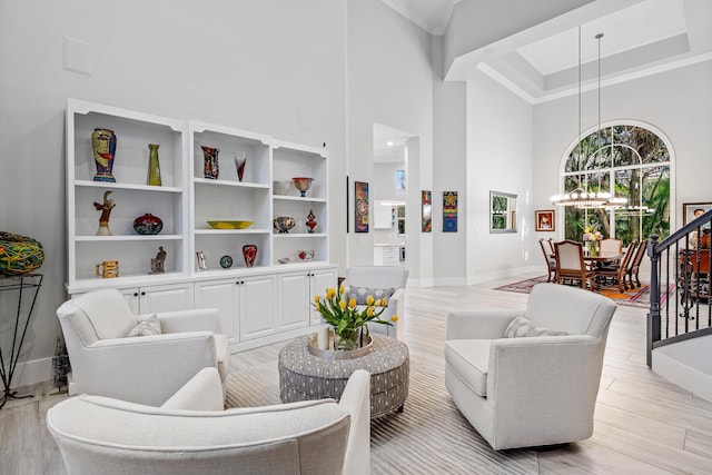 16313 Mira Vista Ln, Delray Beach, FL 33446 - living area featuring a chandelier, a high ceiling, baseboards, light wood-style floors, and ornamental molding