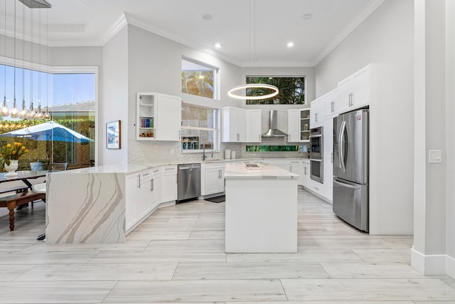 16313 Mira Vista Ln, Delray Beach, FL 33446 - kitchen featuring appliances with stainless steel finishes, wall chimney exhaust hood, ornamental molding, light stone counters, and white cabinetry