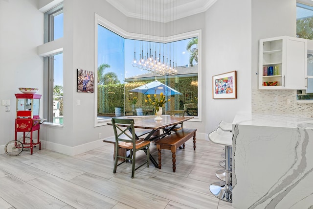 16313 Mira Vista Ln, Delray Beach, FL 33446 - dining room with a towering ceiling, crown molding, baseboards, and light wood-style floors