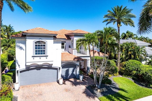 16313 Mira Vista Ln, Delray Beach, FL 33446 - mediterranean / spanish home featuring a tile roof, an attached garage, stucco siding, and a balcony