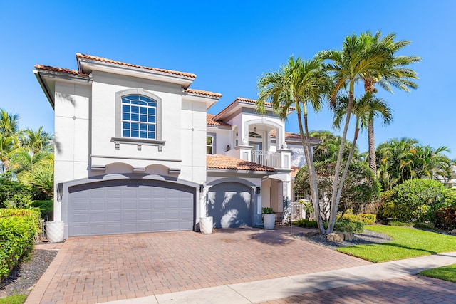 16313 Mira Vista Ln, Delray Beach, FL 33446 - mediterranean / spanish-style house with a balcony, a tiled roof, an attached garage, decorative driveway, and stucco siding