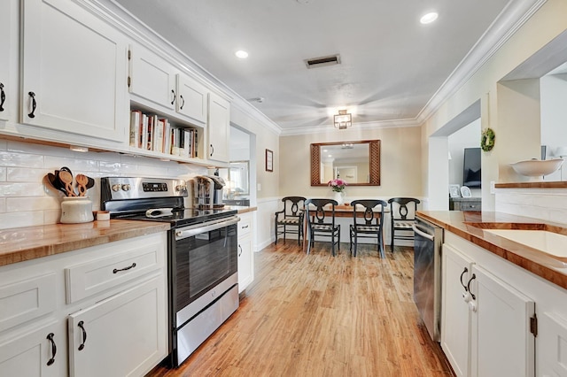 18428 Alydar Way, Boca Raton, FL 33496 - kitchen with stainless steel appliances, white cabinets, crown molding, decorative backsplash, and light wood finished floors