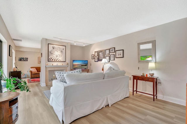 1518 15th Ln, Palm Beach Gardens, FL 33418 - living room with light wood-style floors, track lighting, and a textured ceiling